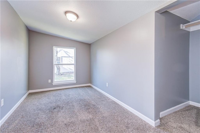 carpeted empty room with lofted ceiling