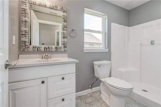 bathroom with vanity, toilet, and a shower