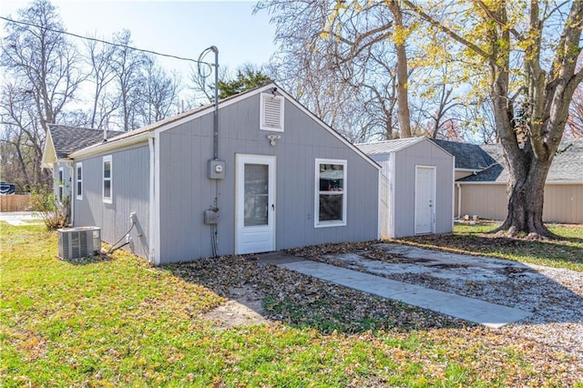 view of front of home with central AC and a front yard