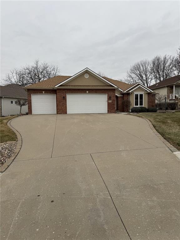 view of front of home with brick siding, driveway, and an attached garage