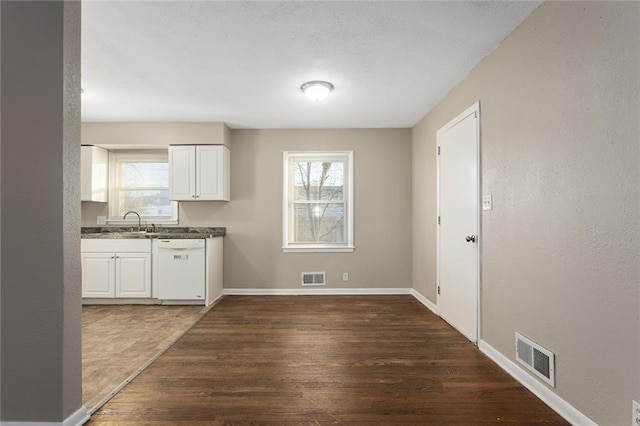 kitchen with a healthy amount of sunlight, white cabinets, and white dishwasher