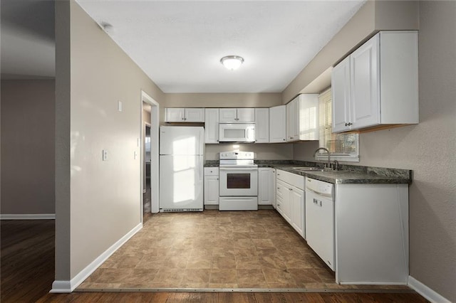 kitchen featuring sink, white cabinets, and white appliances