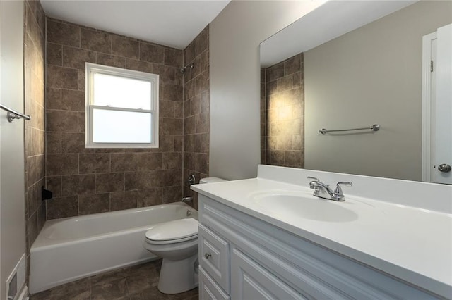 full bathroom featuring tiled shower / bath, vanity, and toilet