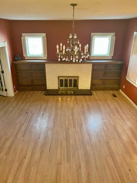 unfurnished dining area with a chandelier and light hardwood / wood-style floors