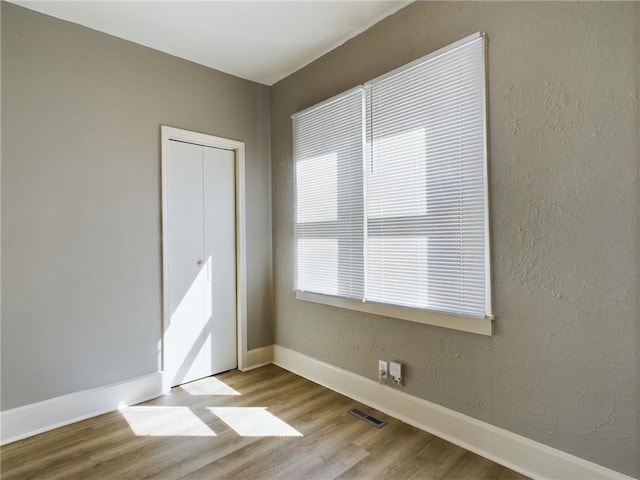 unfurnished bedroom featuring a closet and light hardwood / wood-style flooring