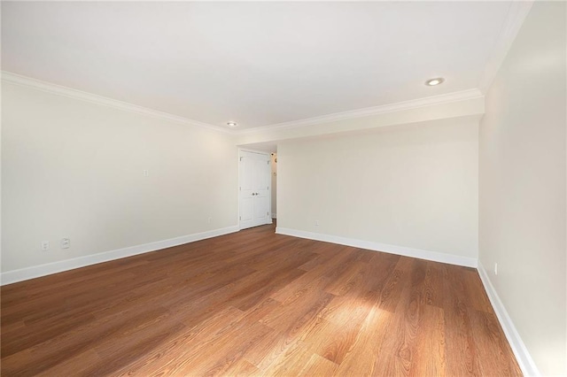 empty room featuring hardwood / wood-style floors and crown molding