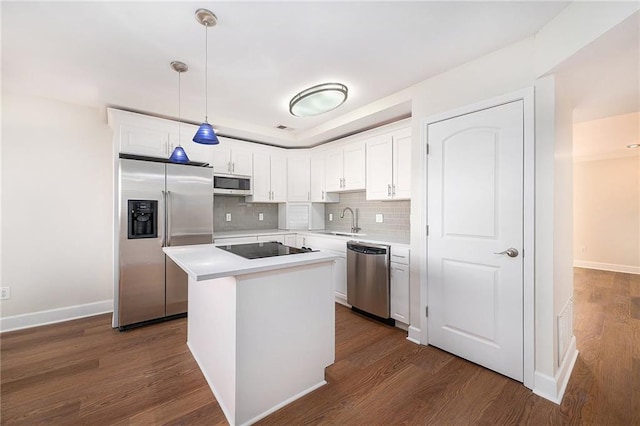 kitchen with sink, white cabinetry, appliances with stainless steel finishes, a kitchen island, and pendant lighting