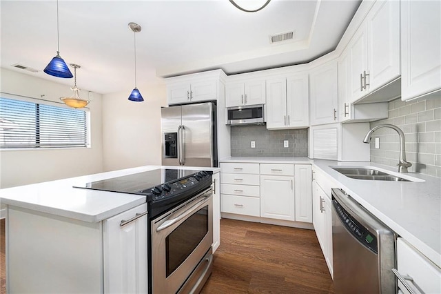 kitchen with sink, hanging light fixtures, dark hardwood / wood-style flooring, stainless steel appliances, and white cabinets