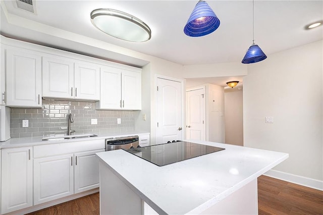 kitchen with white cabinetry, black electric stovetop, a center island, and sink