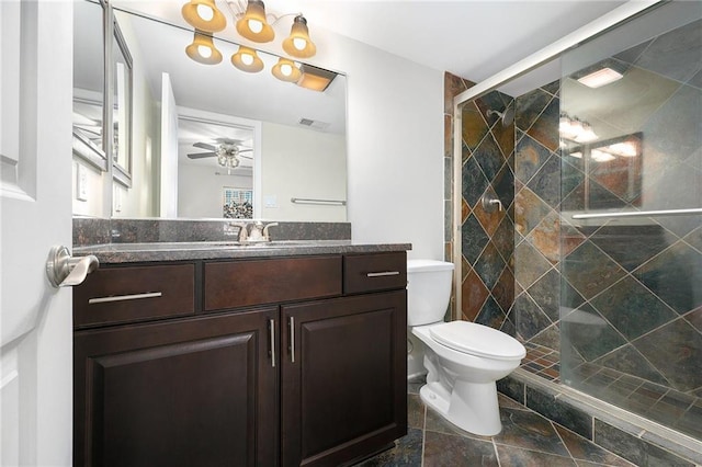 bathroom with walk in shower, ceiling fan, vanity, and toilet