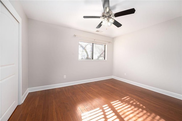 empty room with ceiling fan and dark hardwood / wood-style flooring