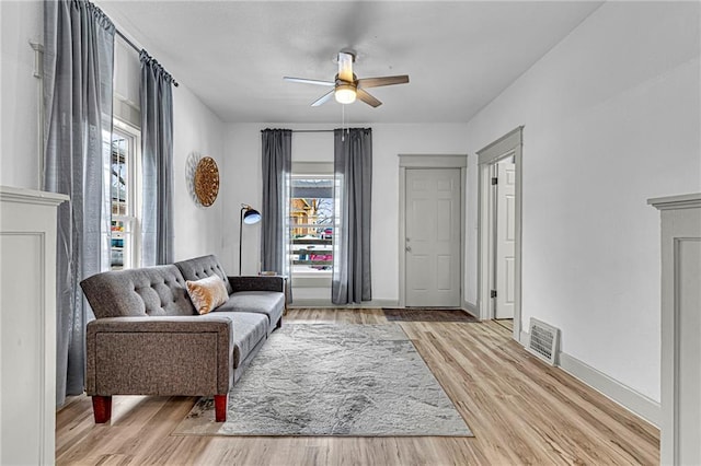 living room featuring light hardwood / wood-style floors and ceiling fan