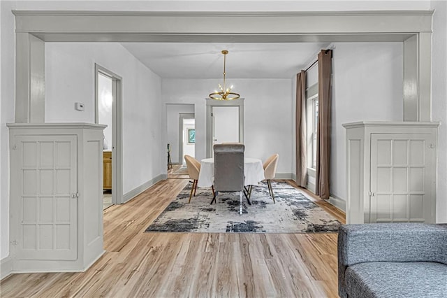 dining space with a notable chandelier and light wood-type flooring