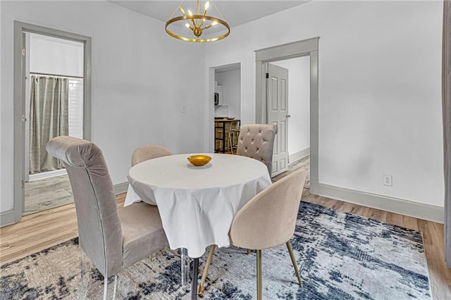 dining area featuring hardwood / wood-style floors and a chandelier