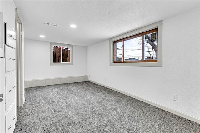 carpeted spare room with a textured ceiling