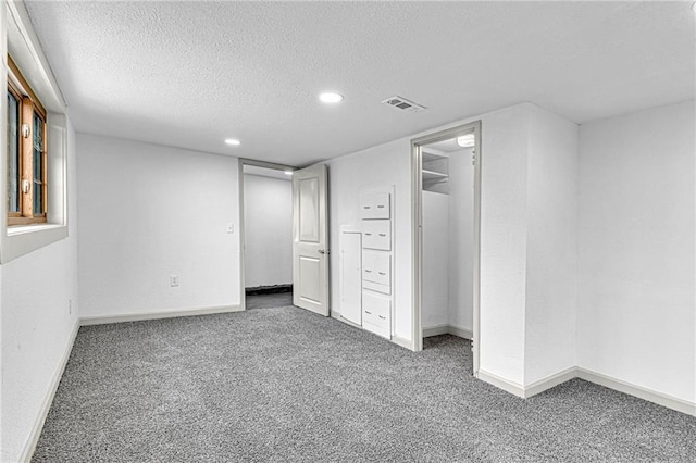 unfurnished bedroom featuring dark carpet and a textured ceiling