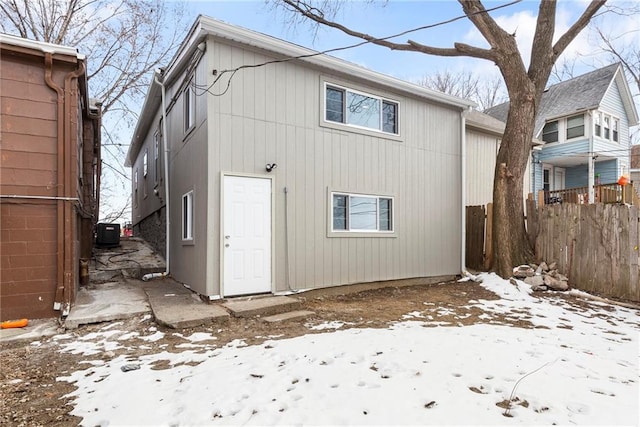 snow covered back of property with central AC unit