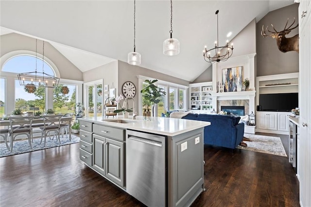 kitchen with dishwasher, pendant lighting, a kitchen island with sink, and sink