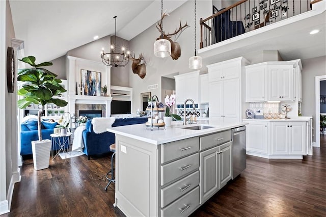 kitchen with sink, dishwasher, a kitchen island with sink, hanging light fixtures, and white cabinets