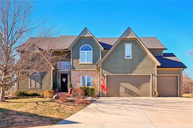 traditional home featuring stone siding, concrete driveway, an attached garage, and stucco siding