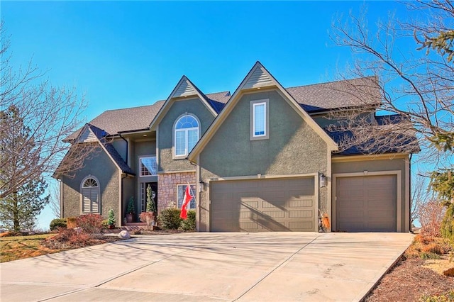 traditional home with a garage, driveway, stone siding, and stucco siding