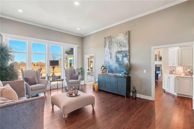 sitting room with dark wood-style floors, baseboards, crown molding, and recessed lighting