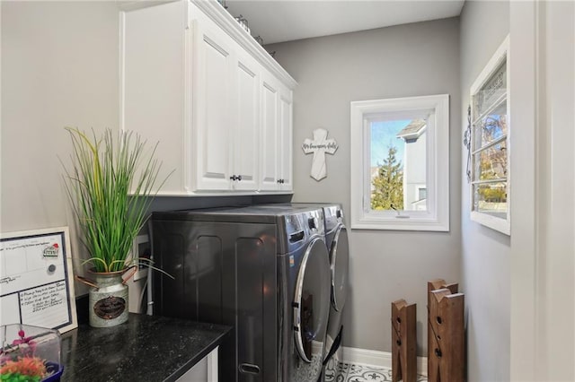 washroom with cabinet space, washing machine and dryer, and baseboards