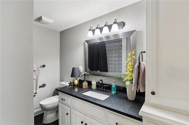 bathroom with visible vents, toilet, a textured ceiling, vanity, and tile patterned floors