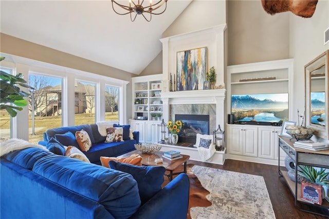14110 Wingfoot Ct, Basehor, KS 66007 - living area with high vaulted ceiling, dark wood-style flooring, a tiled fireplace, built in shelves, and a notable chandelier