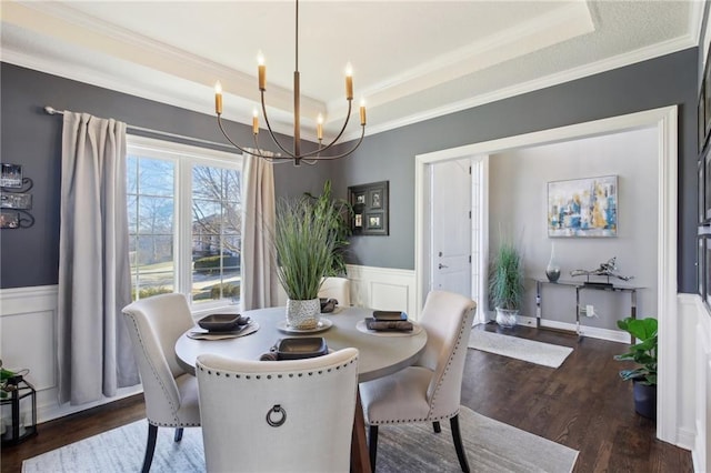 14110 Wingfoot Ct, Basehor, KS 66007 - dining space with dark wood finished floors, a wainscoted wall, a raised ceiling, ornamental molding, and a notable chandelier