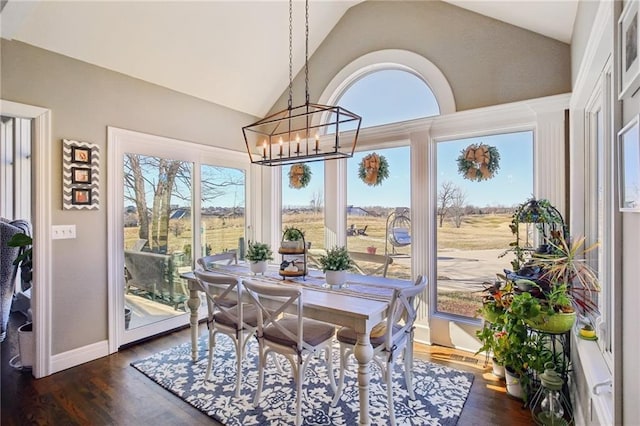 14110 Wingfoot Ct, Basehor, KS 66007 - dining space with vaulted ceiling, a notable chandelier, dark wood-type flooring, and baseboards