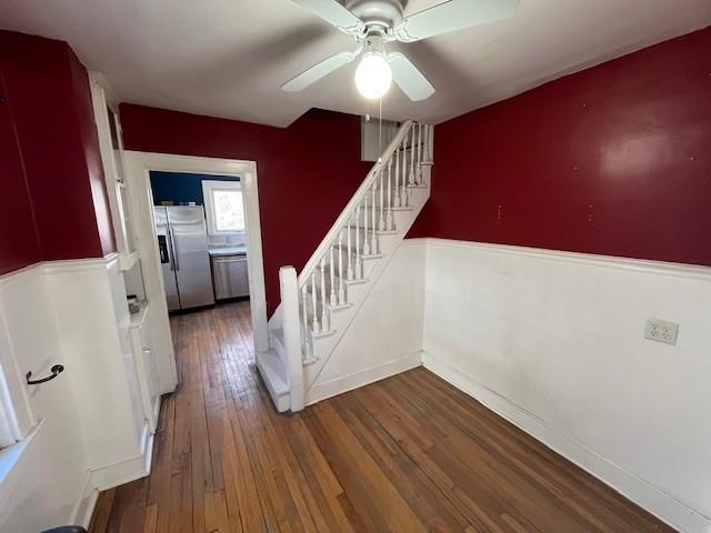 stairway with baseboards, a ceiling fan, and hardwood / wood-style floors