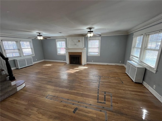 unfurnished living room featuring radiator, stairs, a fireplace, and hardwood / wood-style floors