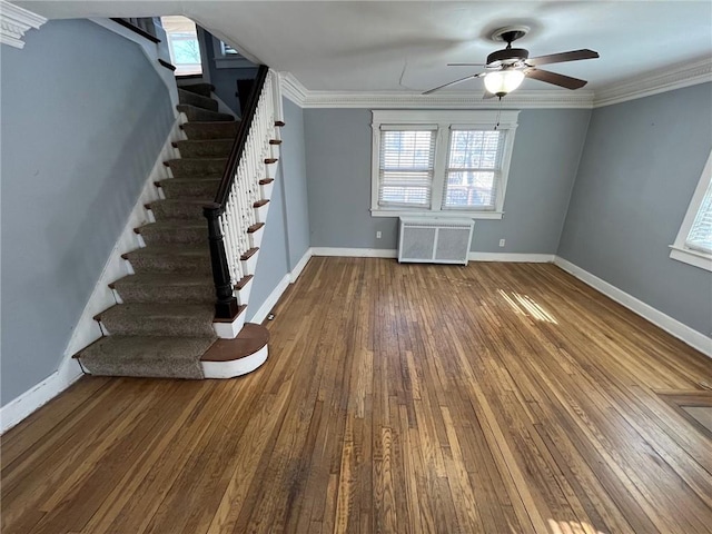 interior space featuring dark wood-style floors, ornamental molding, radiator heating unit, and baseboards