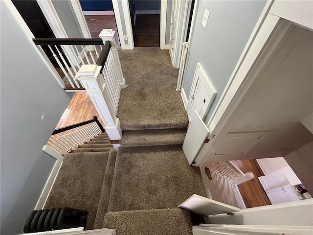 staircase with carpet, baseboards, and attic access