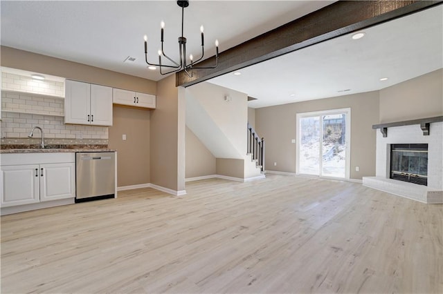 kitchen featuring sink, white cabinetry, tasteful backsplash, light hardwood / wood-style flooring, and stainless steel dishwasher