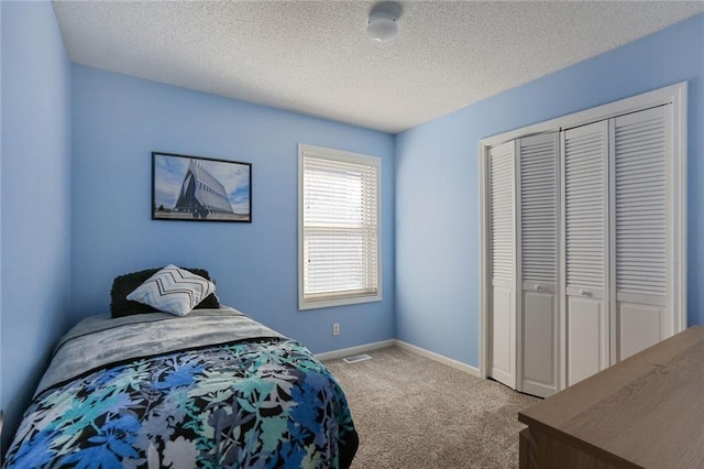 bedroom featuring carpet floors, a textured ceiling, baseboards, and a closet