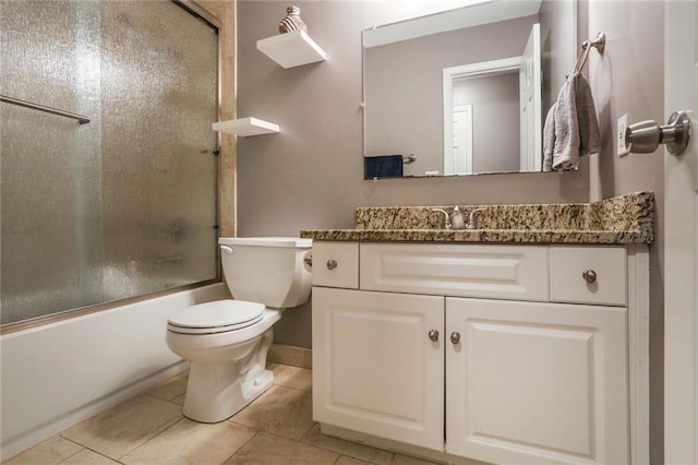 bathroom with toilet, tile patterned flooring, combined bath / shower with glass door, and vanity