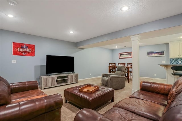 living area with recessed lighting, ornate columns, light colored carpet, and baseboards