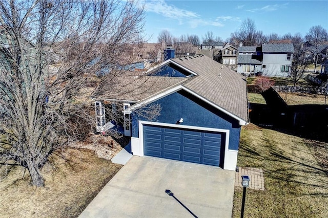 view of front facade with driveway, an attached garage, fence, and stucco siding