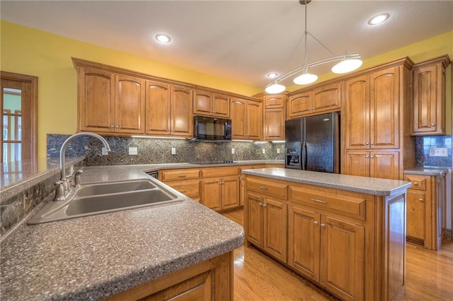 kitchen with sink, light hardwood / wood-style flooring, tasteful backsplash, black appliances, and decorative light fixtures