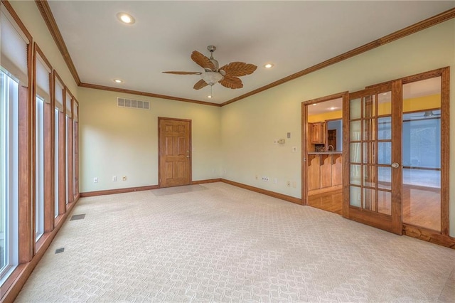 unfurnished room featuring ornamental molding, light colored carpet, ceiling fan, and french doors