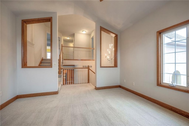 unfurnished room with a chandelier and carpet