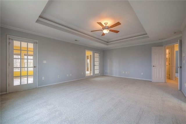 carpeted empty room with crown molding, ceiling fan, and a tray ceiling