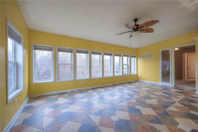 unfurnished room featuring plenty of natural light and ceiling fan