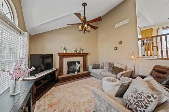 living room featuring a fireplace, vaulted ceiling, and ceiling fan