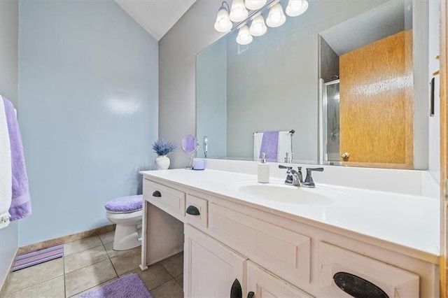 bathroom featuring toilet, vaulted ceiling, vanity, a shower with door, and tile patterned flooring