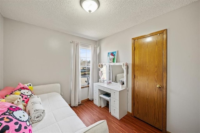 bedroom with wood-type flooring and a textured ceiling