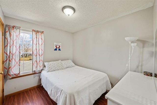 bedroom with dark wood-type flooring and a textured ceiling