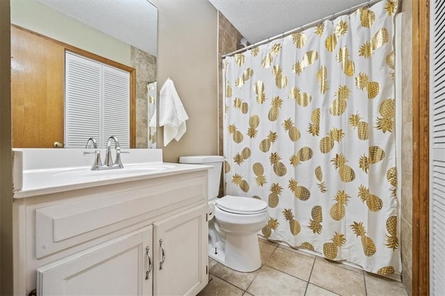 bathroom featuring vanity, tile patterned floors, toilet, and a textured ceiling